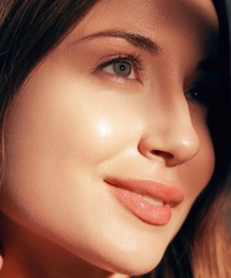 A woman shows her radiant facial skin